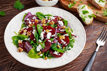 Wall Mural - Healthy Beet Salad with fresh sweet baby spinach, kale lettuce, nuts, feta cheese and toast  melted 