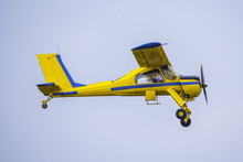 Yellow And Blue Propeller Plane In Flight