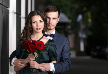 Poster - Elegant couple with bouquet of roses, outdoor