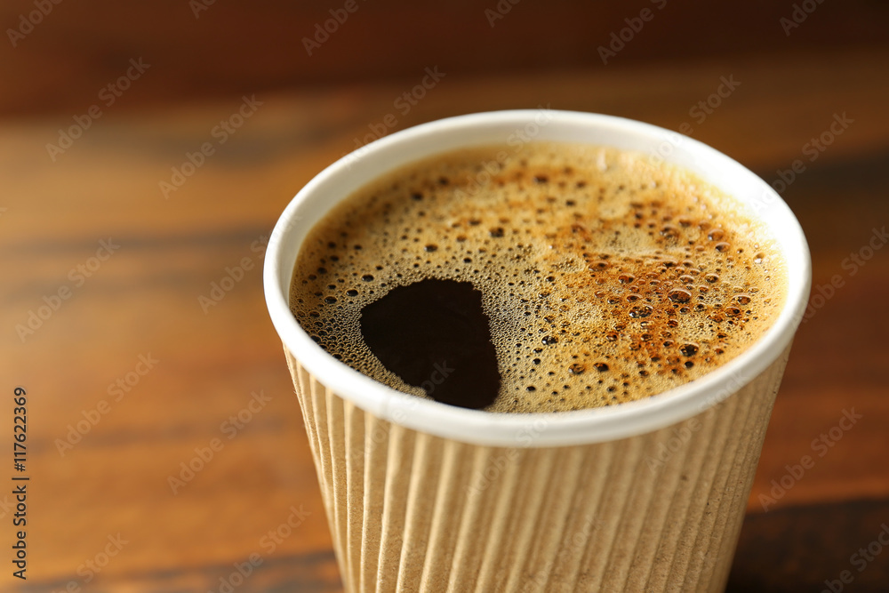 Coffee cardboard cup on wooden background