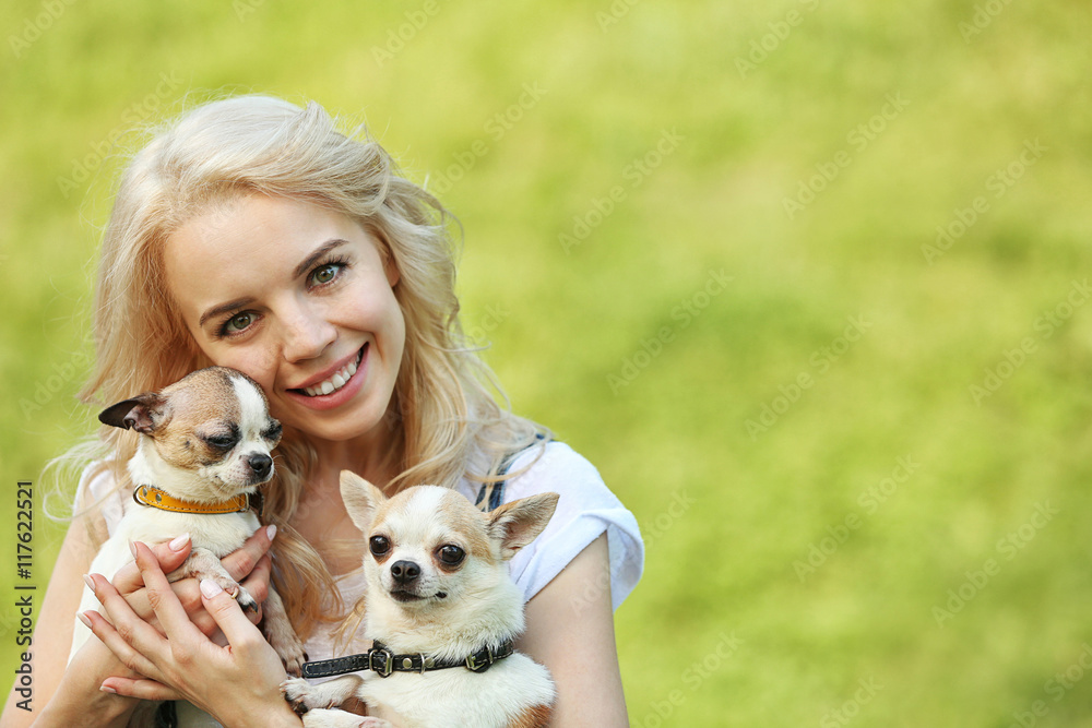 Woman holding fluffy dogs in the park