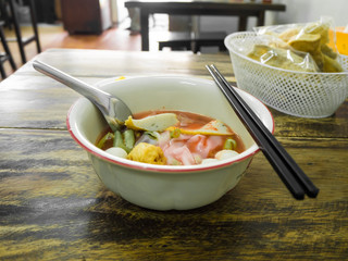 Noodles with seafood soup and red sauce.