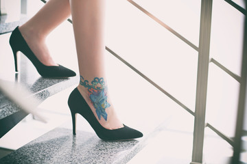 Sticker - Woman with tattoo on her leg in high heeled shoes on the stairs