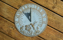 Horizontal Sundial On A Wooden Background Showing Nine O'clock