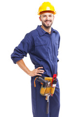 Wall Mural - Worker with tool belt standing smiling on white background