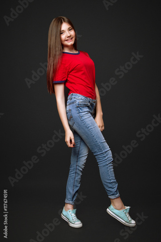 A Beautiful 13 Years Old Girl Dressed In Jeans And Red T Shirt In Studio On Black Background Stock Photo Adobe Stock
