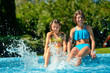 © Iuliia Sokolovska - Kids in swimming pool have fun and splash in water, children on family vacation