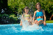 © Iuliia Sokolovska - Kids in swimming pool have fun and splash in water, children on family vacation