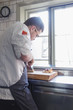 © Astrakan Images - Side view of chef slicing meat in kitchen