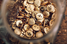 Directly Above Shot Of Jar Filled With Buttons On Table At Workshop