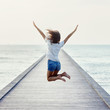 © GVS - Back view of jumping girl on the pier