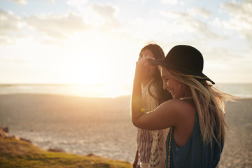 Wall Mural - Female friends walking on the sea shore