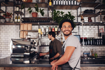 coffee shop owner with barista working in behind