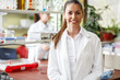Portrait of young female scientist standing in her lab.	