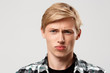 Close up portrait of handsome confident blond young man wearing casual plaid shirt looking in camera isolated on grey background