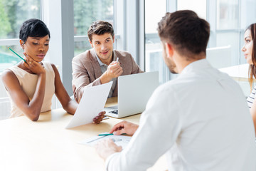 Businesspeople working with laptop at meeting in office