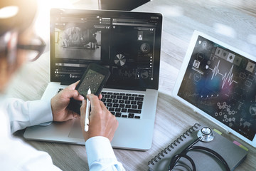 Doctor working with digital tablet and laptop computer with smar