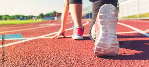 Fotografía Female athlete on the starting line of a stadium track