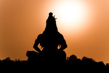 A Silhouette Of A Statue Of The Hindu God Shiva On The Banks Of The Ganges At Rishikesh In North India.