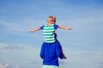 happy father and son playing on sky