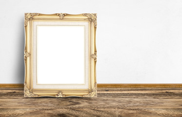 Leinwandbilder - Blank golden vintage picture frame leaning at rustic wooden floo
