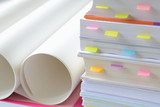 Fototapeta  - Pile of business documents with stick notes and roll of white papers on desk at workplace,high key tone.