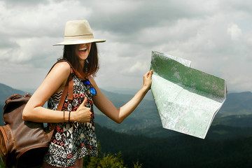 Canvas Print - woman traveler holding map and laughing with hat on eyes on top