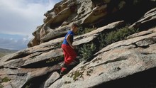 Young Boy Climbing Up The Rock Mountain