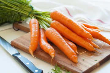 Wall Mural - raw carrot vegetable on wooden chopping board