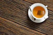 Top View Of A Cup Of Tea With Tea Bag On Wooden Table