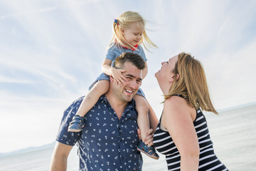 Family of three on beach having fun together