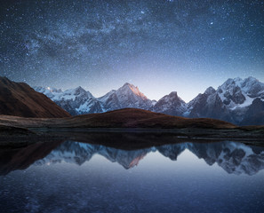 night landscape with a mountain lake and a starry sky