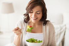 Smiling Young Woman Eating Salad At Home