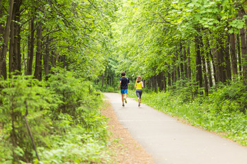 Young couple jogging in park at morning. Health and fitness concept