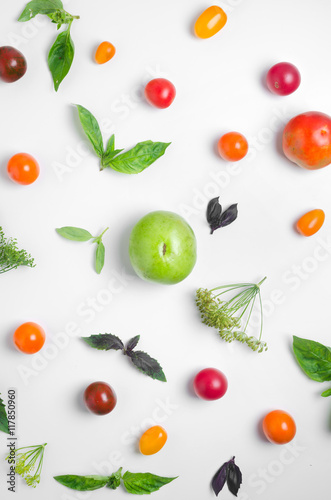Fototapeta na wymiar Food pattern of multicolored tomato basil and dill on top