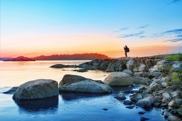 Wall Mural - silhouette of tourist with camera on rocks mysterious island