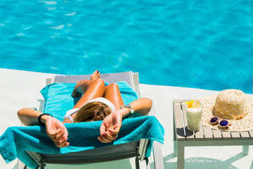 Woman at the poolside with pina colada cocktail