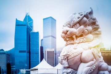 Wall Mural - modern skyscrapers with a majestic stone lion in the foreground,hong kong,china.