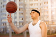 © davstudio - Young man standing on a basketball court.
