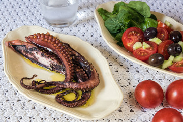 Poster - Tentacles of boiled octopus, served with salad on table