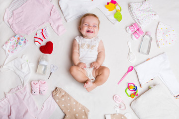 Baby on white background with clothing, toiletries, toys and health care accessories. Wish list or shopping overview for pregnancy and baby shower.

