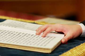 Wall Mural - Hand of boy reading the Jewish Torah at Bar Mitzvah