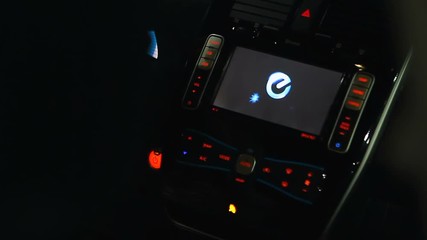 Driver pushing power button to start electric vehicle, modern smart technologies
