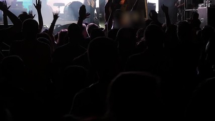 Wall Mural - UKRAINE, VINNITSA - AUGUST 10, 2016: silhouettes of concert crowd in front of bright stage lights