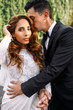 © IVASHstudio - Groom smells bride's hair while she looks gorgeous into the came