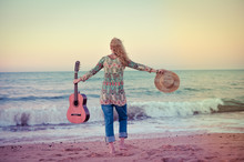 Elegant Woman Walking On The Beach With Guitar Back View, Outdoor Background