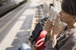 © plprod - femme assise qui allume une cigarette sur un quai de gare