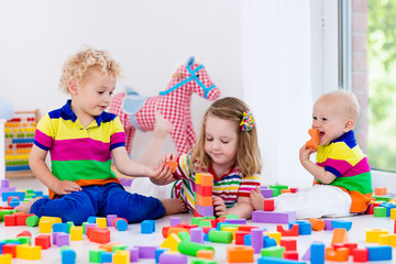 Wall Mural - Kids playing with colorful toy blocks