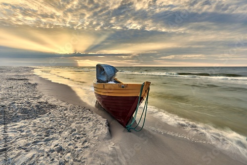 Small boat on the Baltic Sea, in the rays of the setting sun, Poland