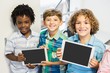 Portrait of students holding digital tablet in classroom